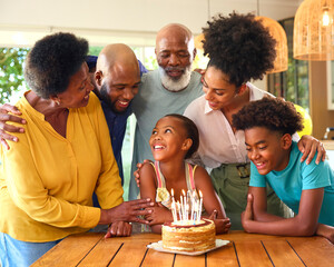Obraz premium Multi-Generation Family Celebrating Granddaughter's Birthday With Cake And Candles At Home