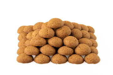 Kruidnoten are crunchy biscuits with gingerbread spices, which are often eaten during the Sinterklaas celebration in the Netherlands. Pyramid of spice nuts from above on a white background.