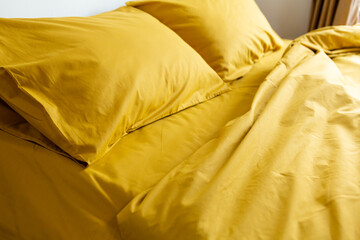 fragment of yellow bed linen pillow and blanket