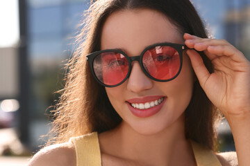 Beautiful smiling woman in sunglasses outdoors on sunny day