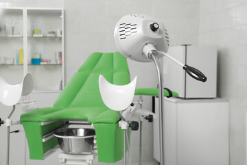 Examination room with gynecological chair and medical equipment in clinic