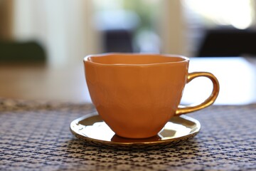Cup of hot drink on table indoors, closeup