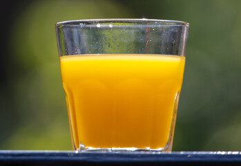 Orange juice in a glass in nature