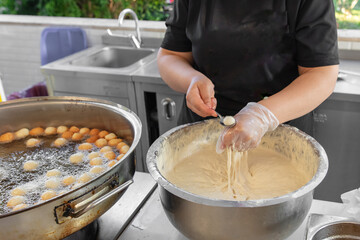 Fototapeta premium Cooking fried donuts in butter