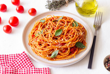 Spaghetti pasta with tomato sauce, basil and Parmesan cheese. Italian cuisine. Vegetarian food.