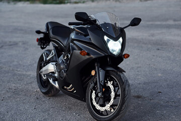 Black colored vehicle. Close up view of modern motorcycle that is parked outdoors