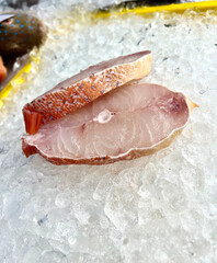 fresh raw cold seafood seven star whole fish ikan head, fillet, meat, cut, tail on white ice...