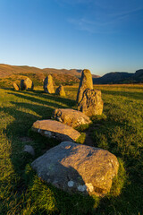 An ancient standing stone circle on high ground surrounded by mountains
