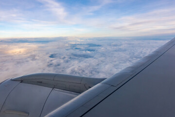 The engine and part of the wing of a passenger plane seen from the window during flight. Shot taken...