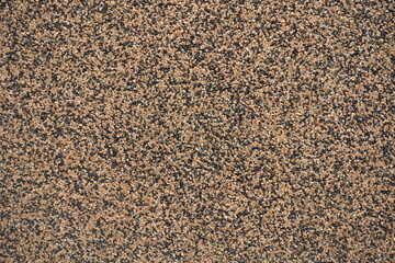 Closeup of wall with coarse brown and black pebbledash finish