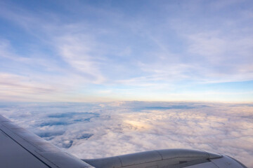 The engine and part of the wing of a passenger plane seen from the window during flight. Shot taken...