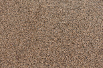 Surface of wall with coarse brown and black pebbledash finish