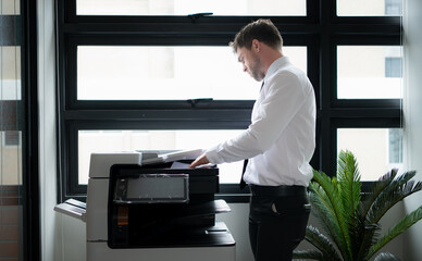 Businessman in office working with copier.