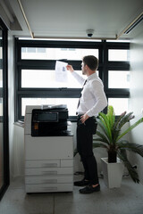 Businessman in office working with copier.