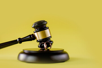 Closeup of wedding rings on wooden mallet at table in courtroom