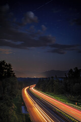 composit lighttrails motorway with nightsky and meteors