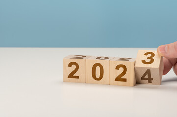 happy new year concept, Flipping of wooden cube block change from 2023 to 2024. Wooden cube with...
