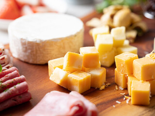Cube-shaped cheese on a wooden cutting board