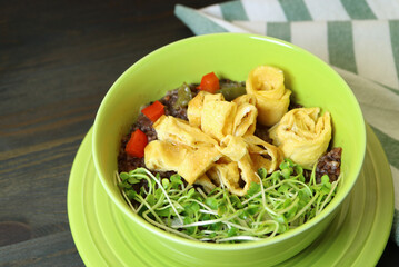Closeup of Riceberry Rice Porridge Topped with Rolled Omelet and Kaiware Daikon Microgreens