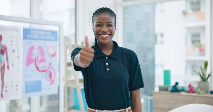 Woman, physiotherapist and thumbs up for healthcare success, thank you and anatomy support in clinic office. Portrait of doctor, African person or physical therapy worker with like, okay or yes emoji