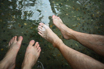 Close-up image of Two male's feet soaking in the hot springs