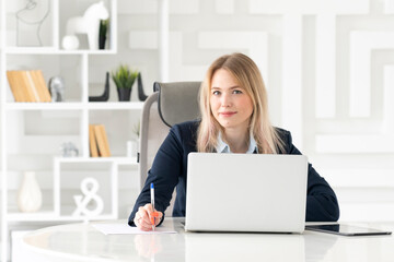 Serious business woman in black suit working in modern office	