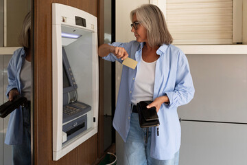 middle-aged woman wants to withdraw money from an ATM