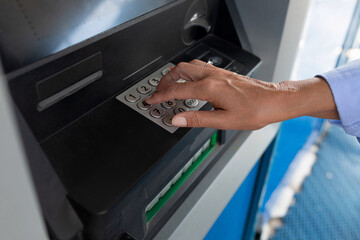 female hand enters pin code at ATM