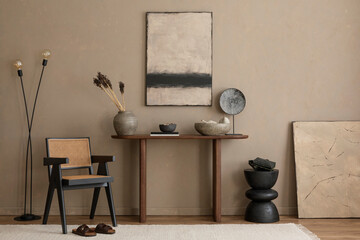Creative composition of warm living room interior with mock up poster frame, wooden consola, stylish lamp, rattan armchair, beige rug, vase with branch and personal accessories. Home decor. Template.