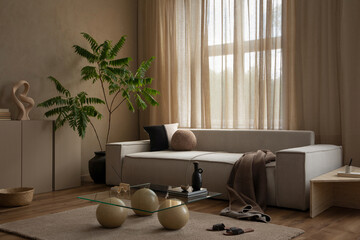 Interior design of warm and cozy living room with modular sofa, stylish glass coffee table, green...