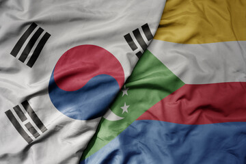 big waving national colorful flag of south korea and national flag of comoros .