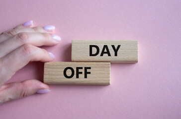 Day off symbol. Concept word Day off on wooden blocks. Businessman hand. Beautiful pink background. Business and Day off concept. Copy space