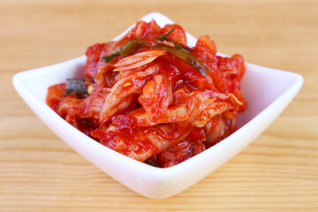 Closeup of Kimchi, an Iconic Korean Dish in White Bowl on Wooden Background