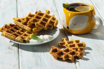 Breakfast on the table Viennese waffles, tea with lemon,