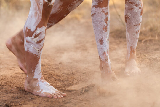Feet of First nations people dancing in oka paint to tell the story kicking up dust