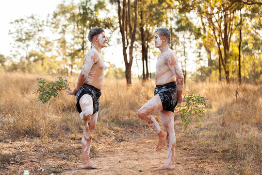 Young aboriginal Australians in their teens doing a dance on country in ochre body paint