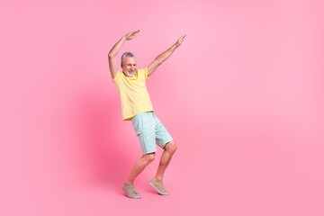 Fototapeta na wymiar Full body photo of model senior funky man raise hands up dancing tiptoes good vibe atmosphere discotheque isolated on pink color background