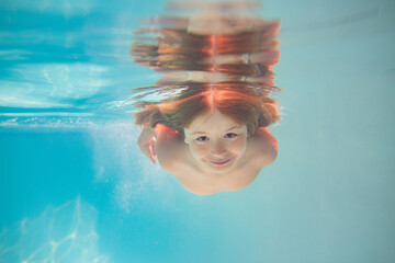 Child in swimming pool underwater. Kid underwater swim. Child splashing underwater in swimming pool. Active kids healthy lifestyle, swim underwater. Summer vacation with child. Child water game.