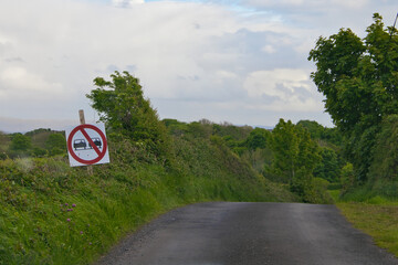 Lonely rural irish road with a sign for no overtaking