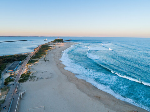 Nobbys beach at sunset with tide coming in seen from aerial perspective