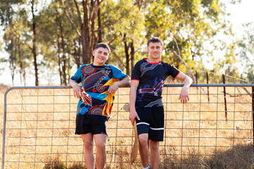 Sixteen year old Aboriginal cousins leaning on gate in country together