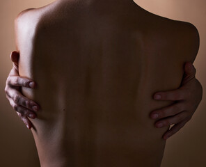 Woman, back and hands touching body on brown background in studio for creative aesthetic, art deco...