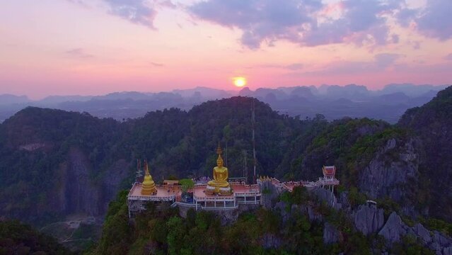 .Aerial view is amazing the golden Buddha was built on the top of a high mountain in amazing sky..scenery stunning sky at sunset above the hilltop..colorful cloudscape. abstract nature background.