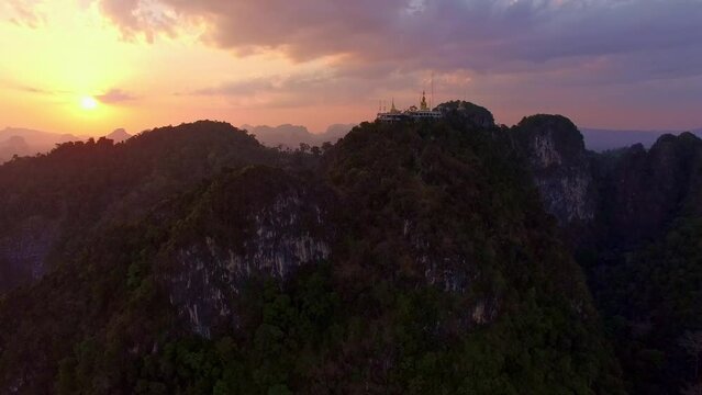 Aerial view is amazing sky at sunset behine The golden buddha on the top of high mountain. .It is more interesting temple complexes in Krabi Thailand, .as the monks live and worship within a maze