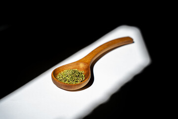 A wooden spoon with oregano.
