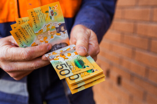 Handyman holding bank notes counting cash received as payment for job completion
