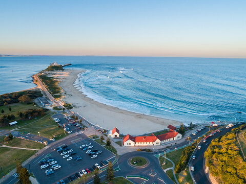 Nobbys Beach Surf Pavilion with sunset light on red building roof and view over ocean in Newcastle