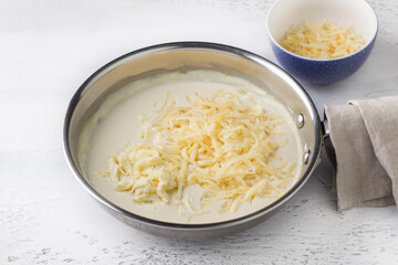 Making cheese sauce for pasta. Add grated cheese and stir. DIY step by step step 8