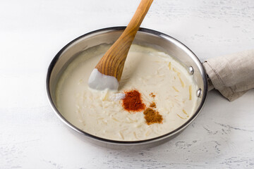 Making cheese sauce for pasta. Add spices: salt, nutmeg and sweet paprika, and stir with a wooden spatula. DIY, step by step, step 9