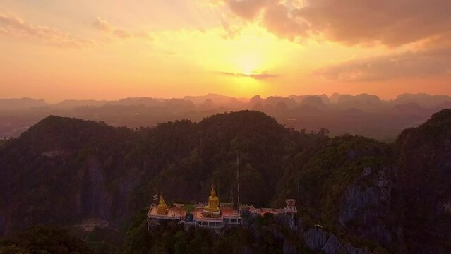 .Aerial view is amazing the golden Buddha was built on the top of a high mountain in amazing sky..scenery stunning sky at sunset above the hilltop..colorful cloudscape. abstract nature background.